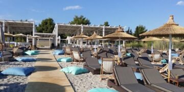 Чадър и шезлонг на Халкидики срещу едно кафе