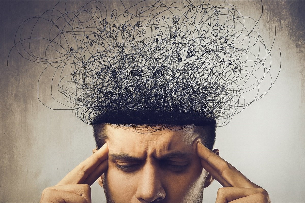 Мъж държи главата си с пръсти в знак на напрежение, а над нея се издигат хаотични линии, символизиращи тревожни мисли и стрес.