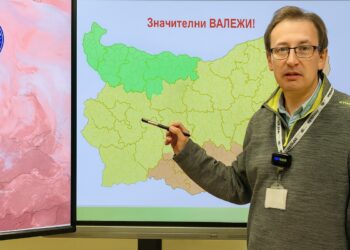 Метеоролог представя прогнозата за времето пред интерактивна карта на България, показваща очаквани значителни валежи и предупреждения за различни региони в страната.