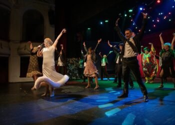 Актьори на сцената в динамична комедийна хореография по време на спектакъл на Варненския драматичен театър.