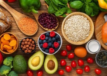 Разнообразие от здравословни храни: плодове, зеленчуци, ядки, семена, овес и сьомга върху дървена повърхност