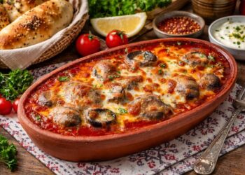 Гювеч с гъби в доматен сос и разтопен кашкавал, сервиран с топъл хляб и ароматни подправки в керамичен съд, апетитно поднесено ястие