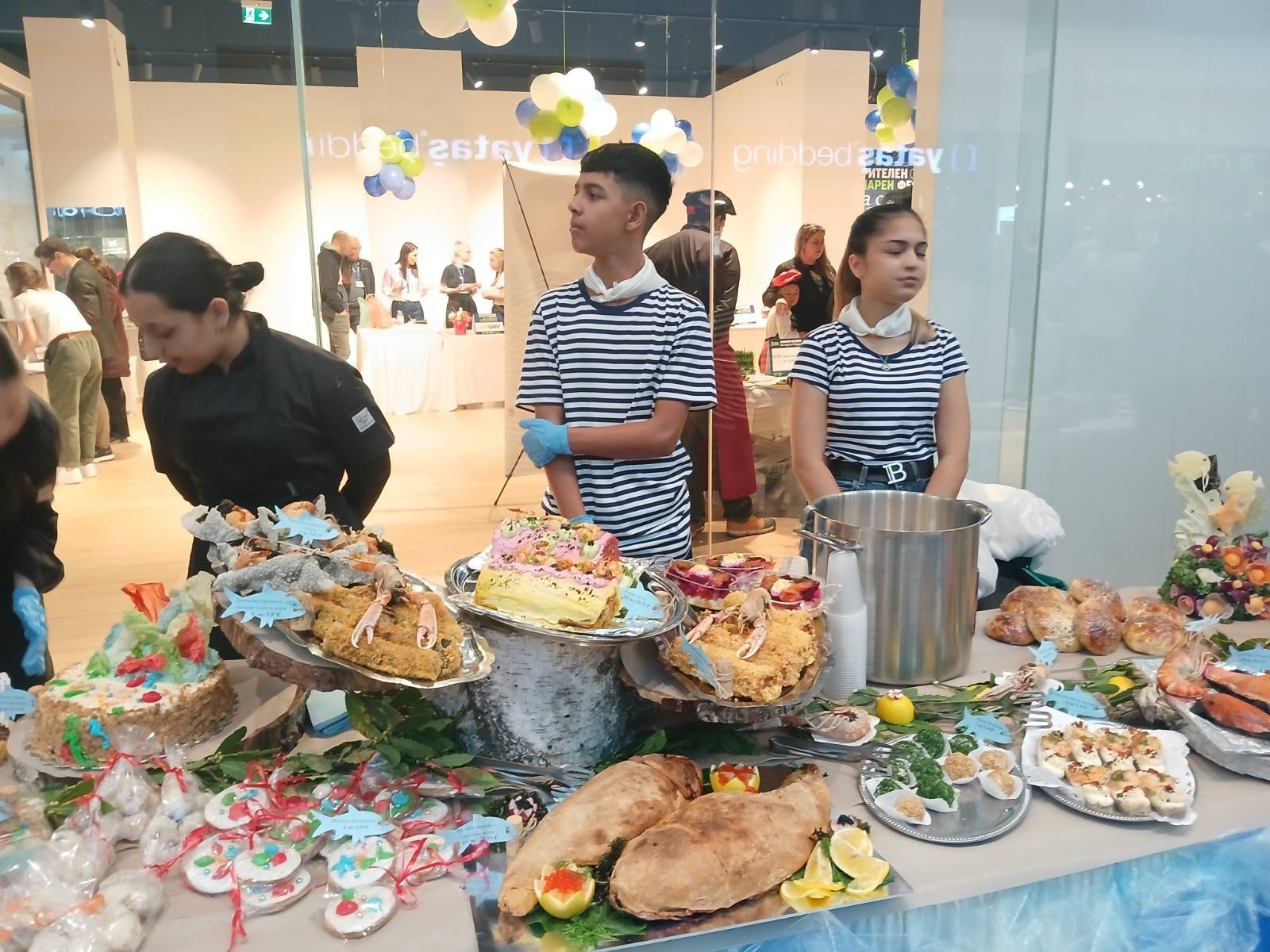 Кулинарният фестивал „Да споделим Никулден“ във Варна – щандове с рибни специалитети, участници от професионални гимназии и ресторанти, празнична атмосфера и благотворителна инициатива.