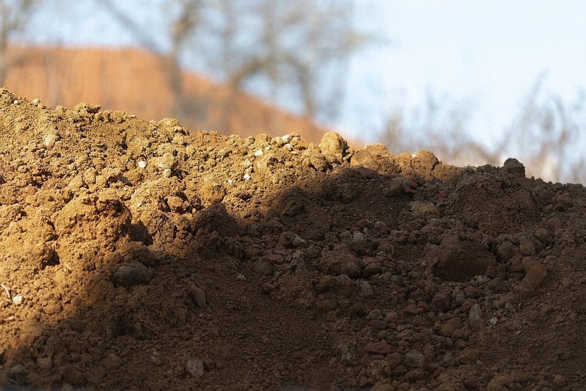 Купчина прясно изкопана почва и камъни на открито, заснета в близък план при дневна светлина.