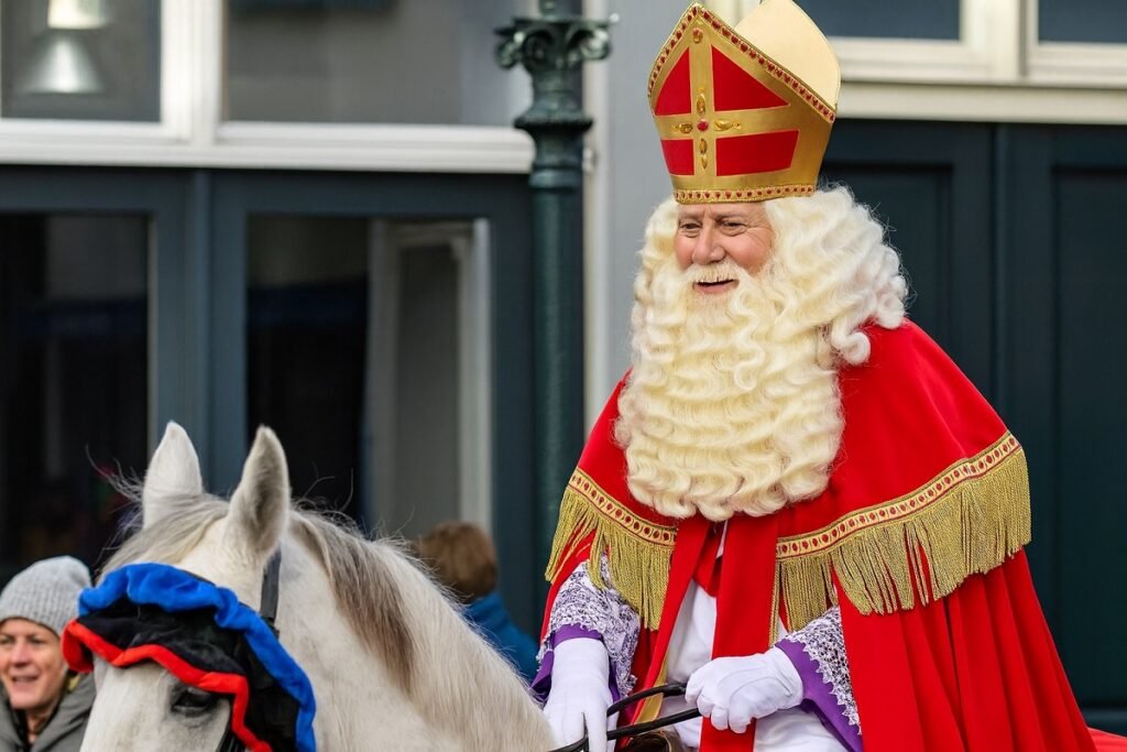Празничен образ на Свети Николай / Синтерклаас – мъж в червена мантия и златна митра, яздещ бял кон по време на традиционно шествие.