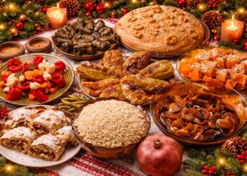 Традиционна българска коледна постна трапеза с питка, сарми, пълнени чушки, боб, жито и тиквеник, подредени в празнична обстановка с коледна украса.