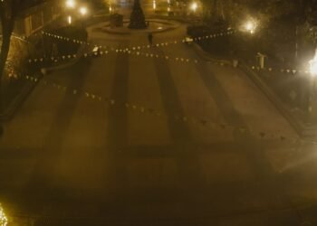 Нощен изглед към централния площад в Белослав, заснет от висока позиция, с осветена коледна елха и празнични гирлянди, озарени от улични лампи.