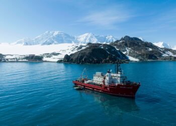 Екипажът на НИК 421 на фона на антарктическия бряг на остров Ливингстън