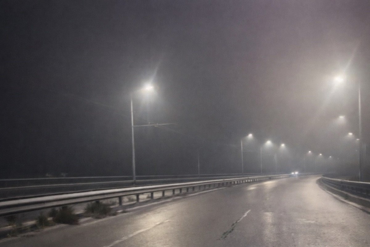 Мъгливо утро на Аспаруховия мост във Варна – празно пътно платно, мокър асфалт и улични лампи с ограничена видимост
