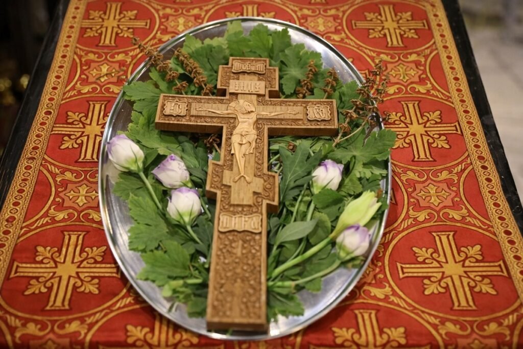 „Свещеник освещава вода с кръст и китка босилек по време на Зимен Кръстовден“