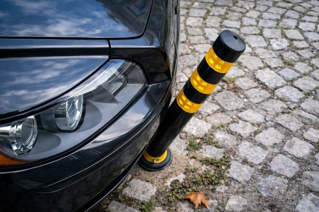 Метално ограничително колче до паркиран автомобил на тротоар във Варна, предназначено да възпрепятства навлизането на коли в пешеходна зона