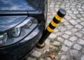 Метално ограничително колче до паркиран автомобил на тротоар във Варна, предназначено да възпрепятства навлизането на коли в пешеходна зона
