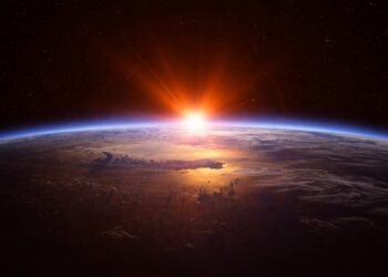 Реалистичен изгрев на Слънцето над земния хоризонт, наблюдаван от Космоса, с ясно очертана кривина на Земята, сияйна атмосфера и звезден фон в хоризонтална композиция.