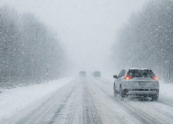 Зимен път с автомобили при силен снеговалеж и намалена видимост по време на оранжев код