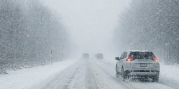 Зимен път с автомобили при силен снеговалеж и намалена видимост по време на оранжев код