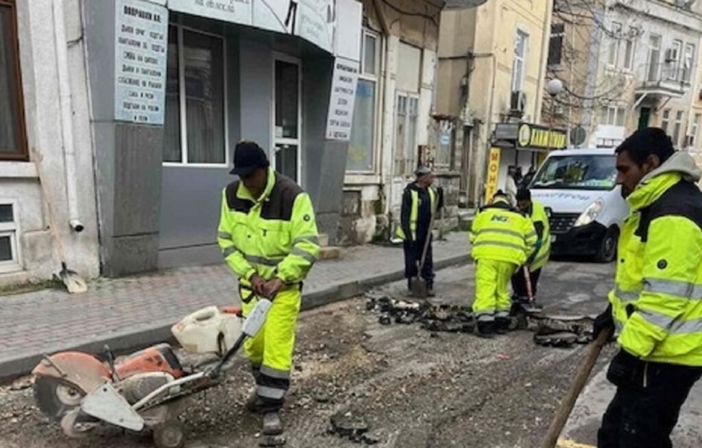Работници режат и подготвят асфалт при ремонт на улица в район „Одесос“ във Варна
